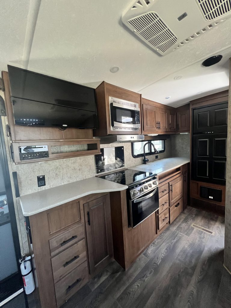 10ft long kitchen with microwave, 3-burner stove, oven, microwave, 7 cu ft refrigerator, and 32" TV