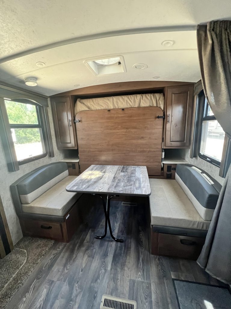 Dining table with wall-bed folded up in 19MKS travel trailer